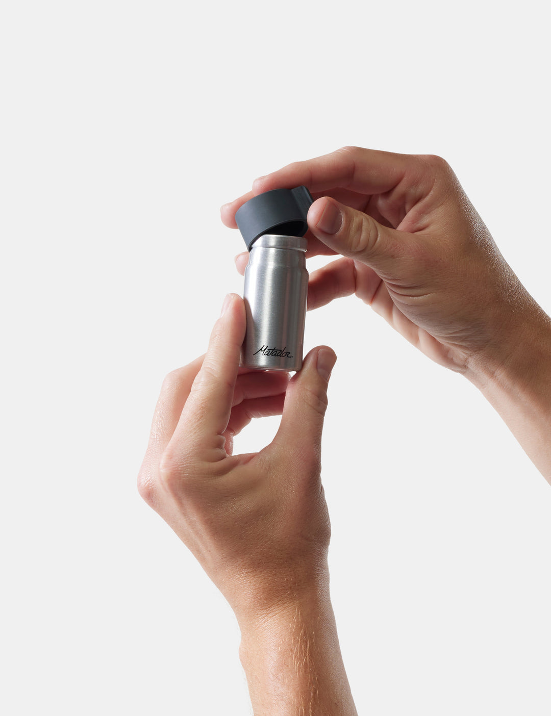 Matador Waterproof Travel Canister - 40ml - person holding a silver and black container against a white background