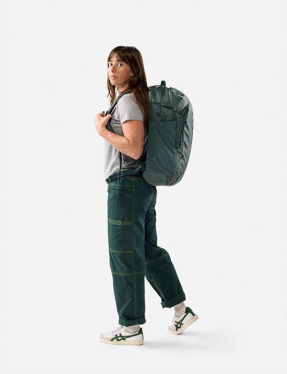 Matador 30L Carry-On Travel Pack in Juniper - person wearing a green backpack on a white background