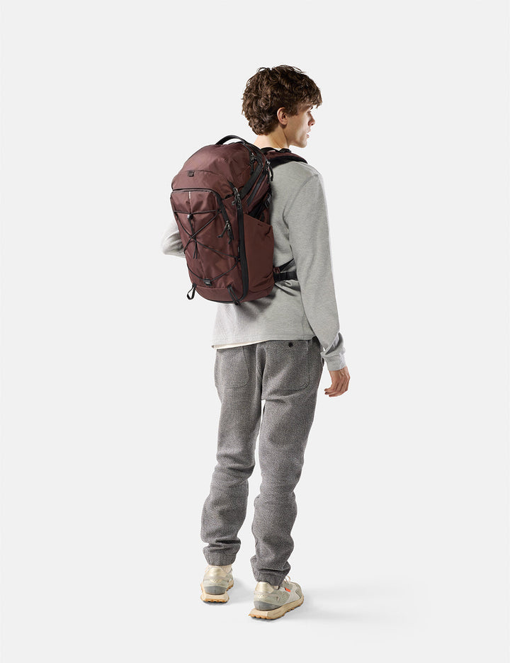 Matador 24L Adventure Pack in Garnet - person wearing a garnet backpack on a white background