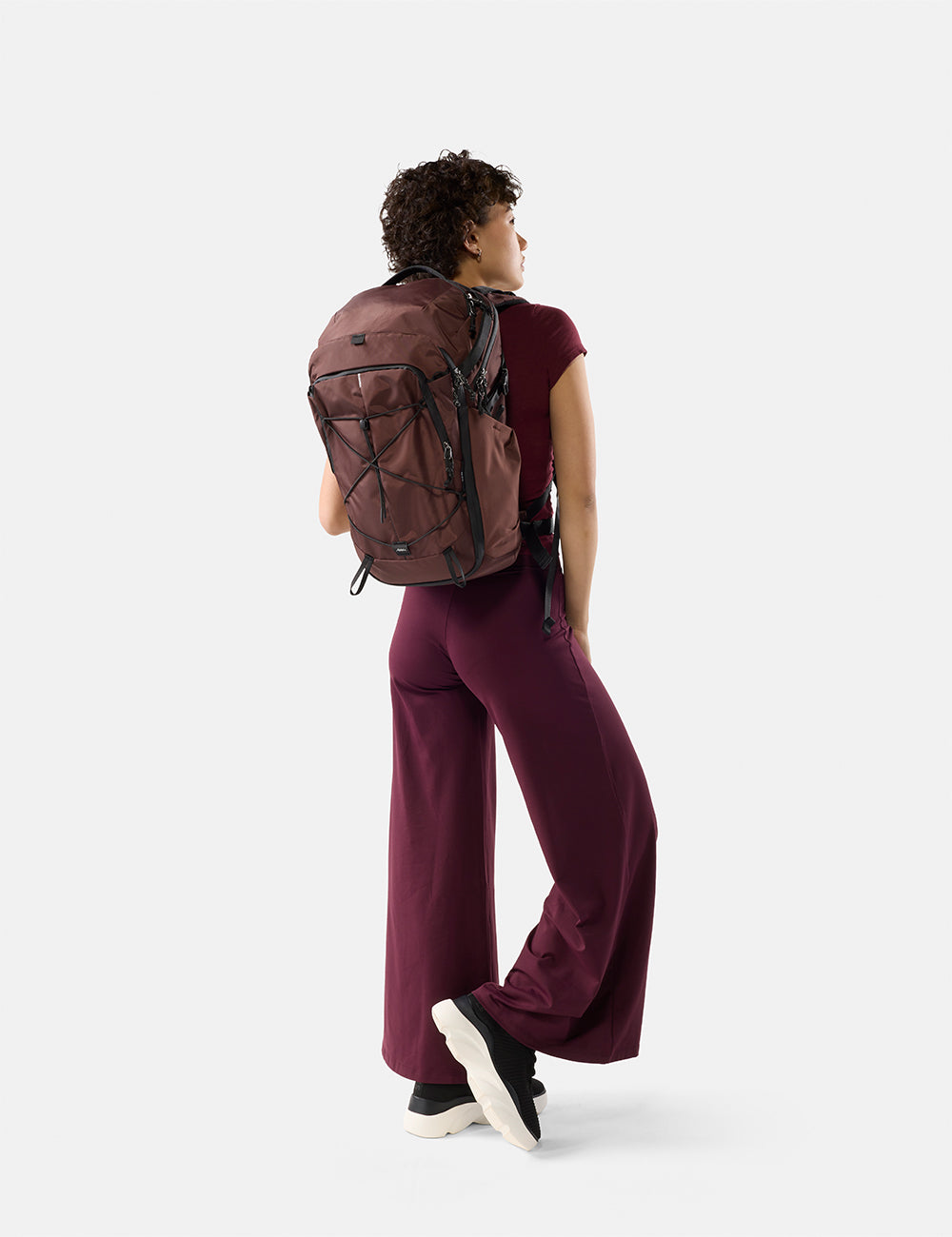 Matador 24L Adventure Pack in Garnet - person wearing a garnet backpack on a white background