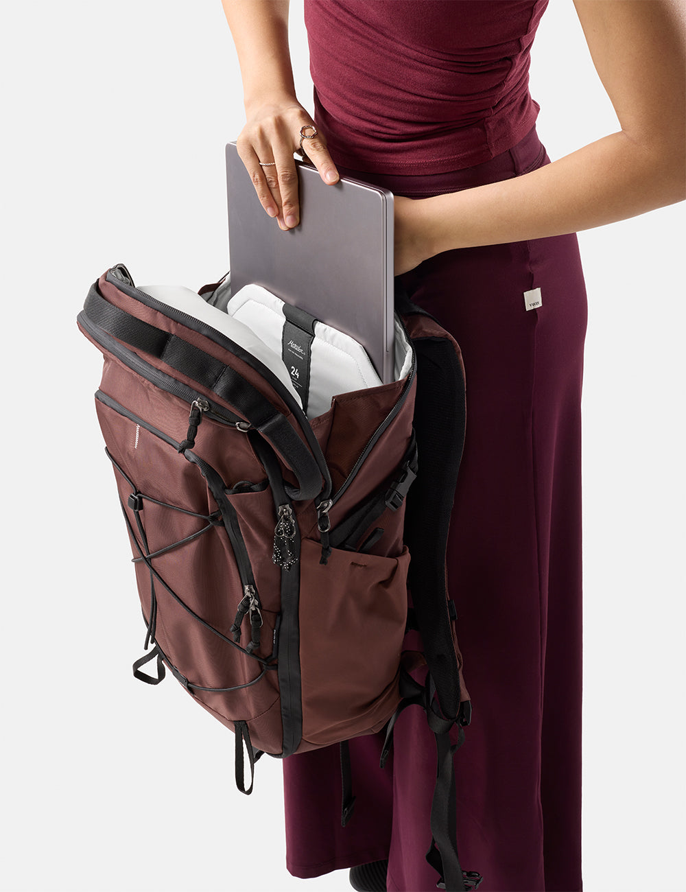 Matador 24L Adventure Pack in Garnet - person holding a garnet backpack with a laptop inside