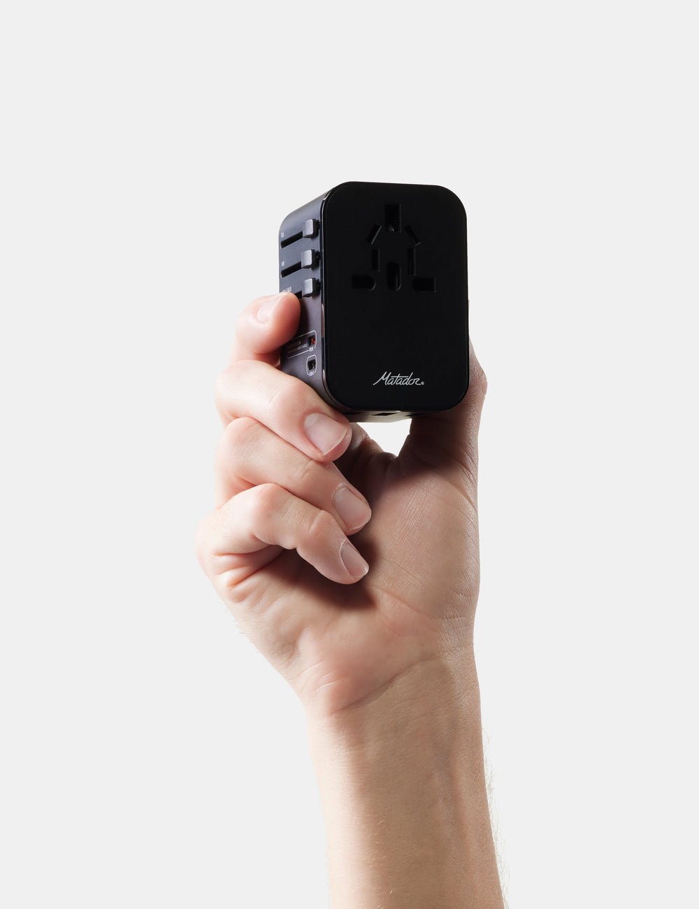 Matador Global Travel Adapter in Black - hand holding a black travel adapter with 'Matador' branding on a white background