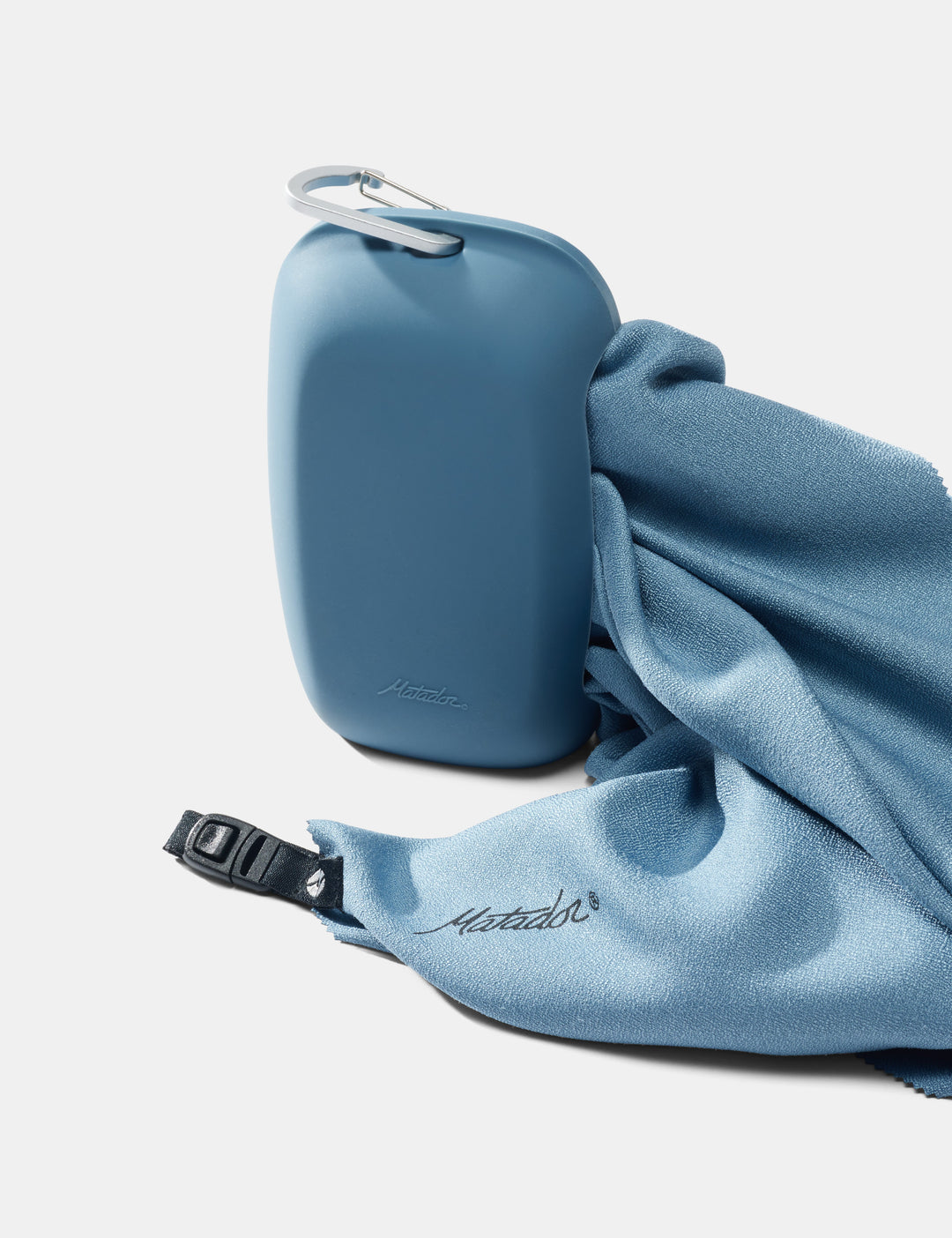 Matador NanoDry Towel - Large 132 x 60cm in Blue - slate towel coming out of silicone case on a white background