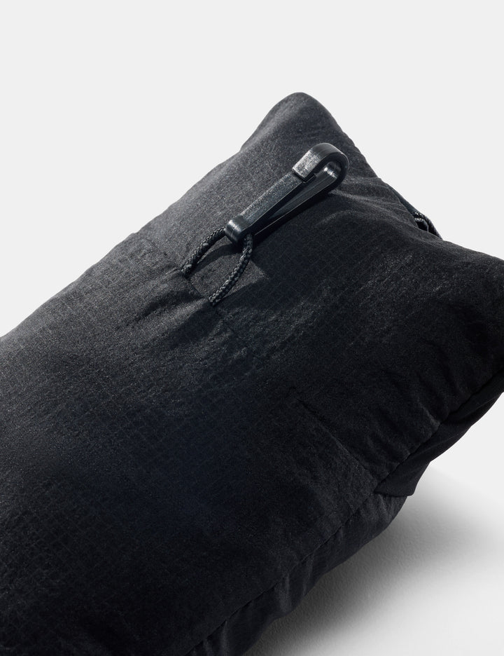 Matador Blackout Travel Pillow - back view of packed up black neck pillow showing small hook