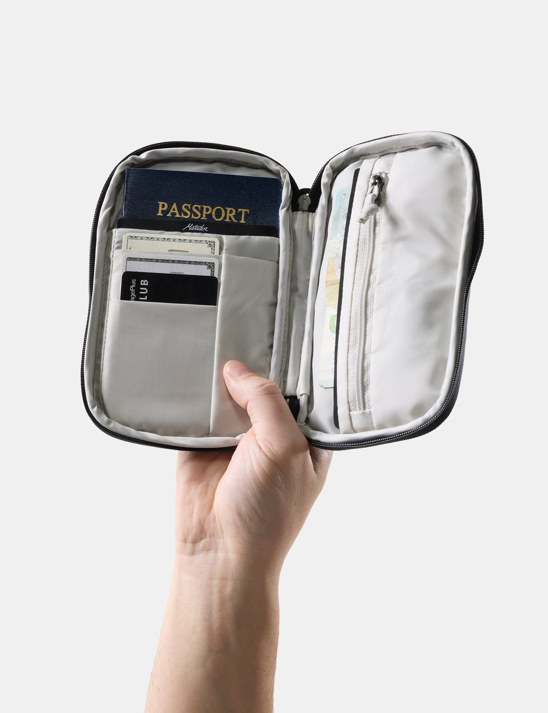 Matador Global Travel Stash in Black - hand holding open travel wallet with passport and credit cards