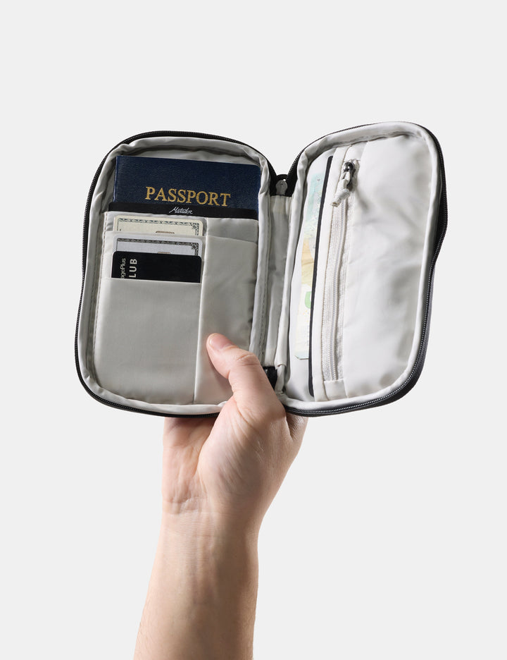 Matador Global Travel Stash in Black - hand holding open travel wallet with passport and credit cards