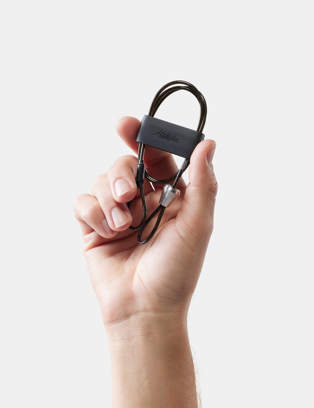 Matador BetaLock Accessory Cable (60cm) - hand holding a black cable with a visible brand logo against a light background