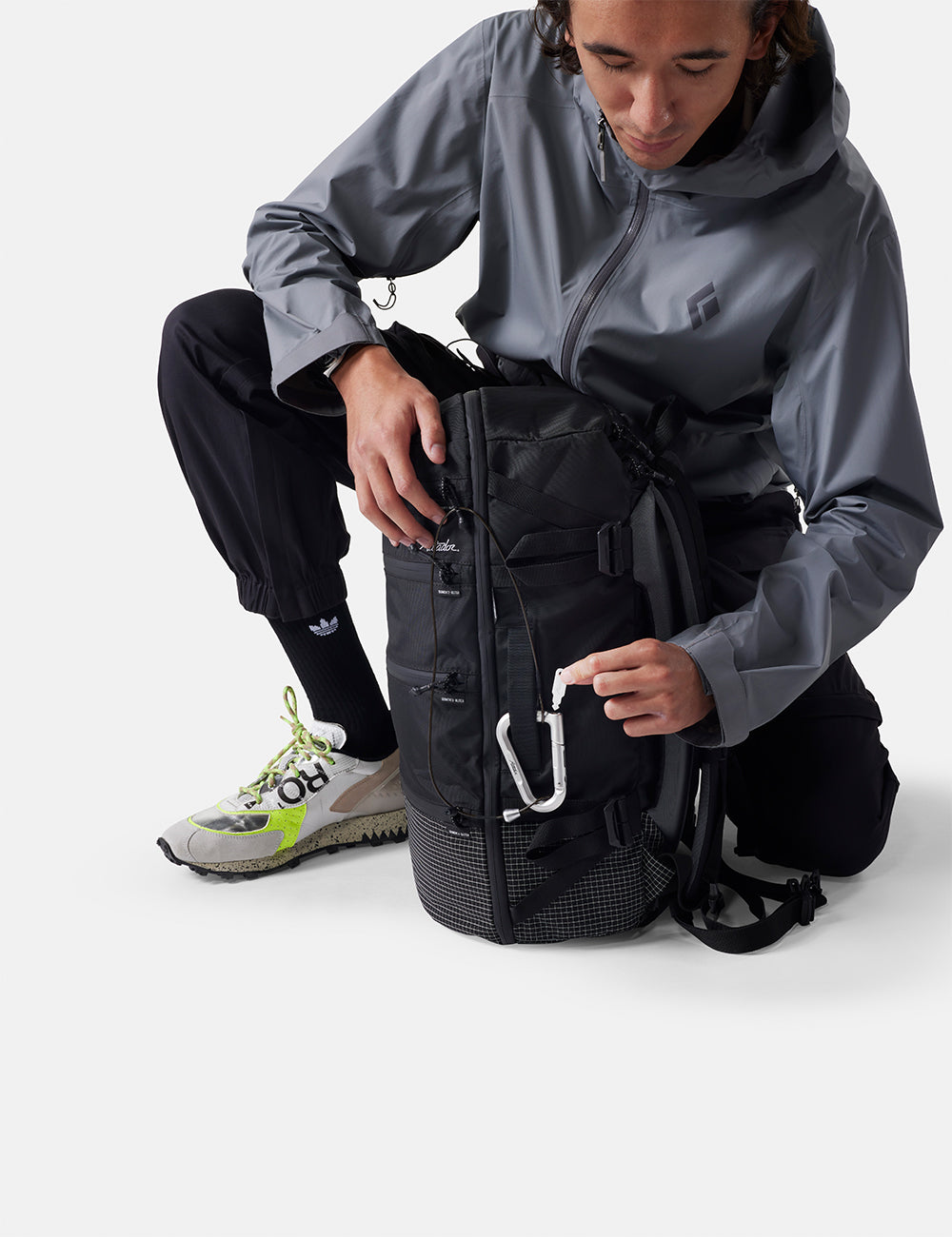 Matador BetaLock Accessory Cable (60cm) - person in gray jacket and black pants with a black backpack on a white background