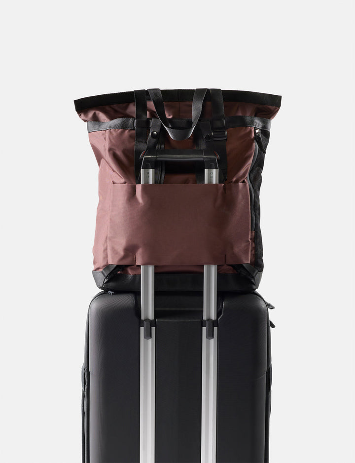 Matador 24L Tote Pack in Garnet - black suitcase with a garnet backpack on top against a white background