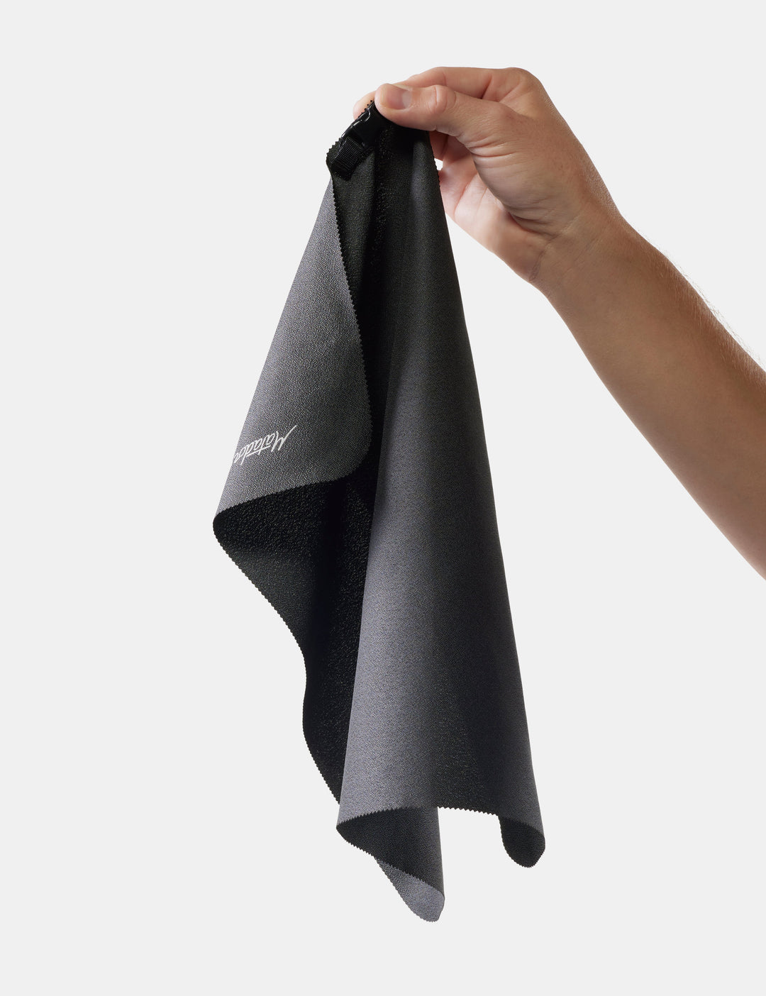 Matador Ultralight Travel Towel - Small 39 x 39cm - person holding a gray towel with a brand logo on a white background